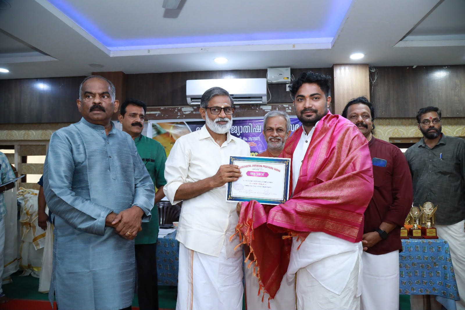 Akhil receiving an award and ceremonial shawl