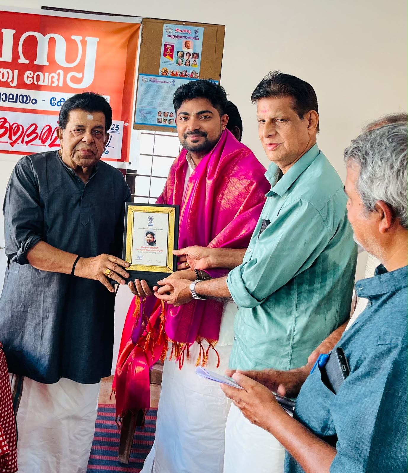 Akhil felicitated with a plaque and pink shawl